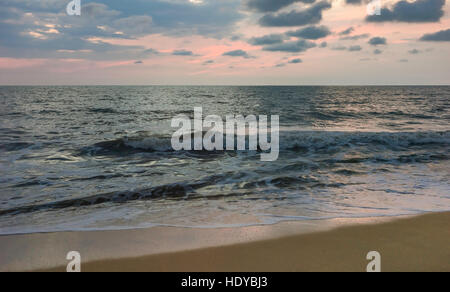 Vue de la plage de sable de l'autre côté de la mer d'Oman au coucher du soleil sur une soirée tranquille à Thottada Village, près de Mumbai, en Inde. Banque D'Images