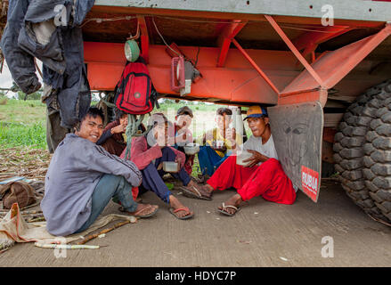 Champ de canne à sucre les ouvriers prennent une pause-déjeuner sous leur camion pour éviter la chaleur à Ma'ao, Negros occidental, aux Philippines. Banque D'Images