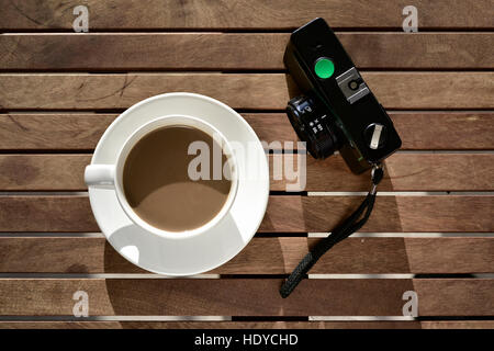 Capture d'un grand angle d'une tasse en céramique blanche avec du blanc et un vieux café d'une caméra table rustique en bois Banque D'Images