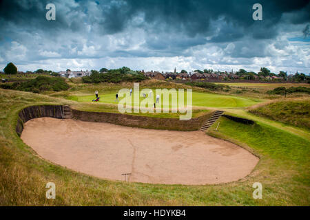 Club de Golf de Prestwick green et bunker d'énormes nuages sombres sous un ciel menaçant le golf en Ecosse Banque D'Images