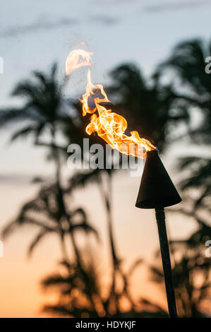 Torches Tiki au coucher du soleil sur la plage de Poipu, Kauai, Hawaï. Banque D'Images