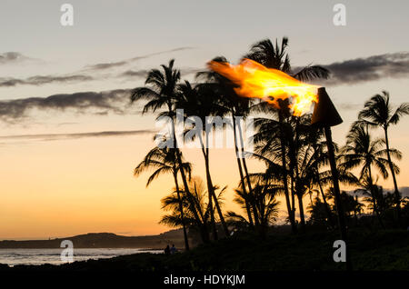 Torches Tiki au coucher du soleil sur la plage de Poipu, Kauai, Hawaï. Banque D'Images