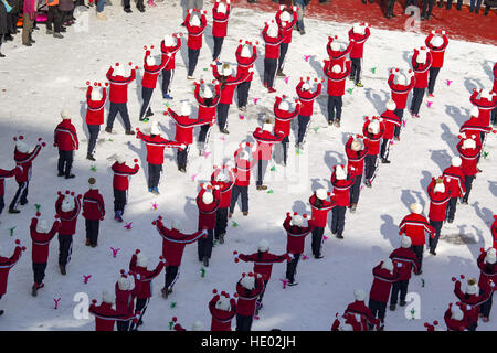 Jilin, Chine. Le 15 décembre, 2016. Quatre cents élèves en uniforme rouge faisant des exercices thématiques de sports d'hiver sur l'aire couverte de neige à l'école primaire de Jilin, nord-est de la Chine, la province de Jilin, le 15 décembre 2016. © SIPA Asie/ZUMA/Alamy Fil Live News Banque D'Images