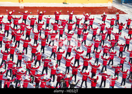 Jilin, Chine. Le 15 décembre, 2016. Quatre cents élèves en uniforme rouge faisant des exercices thématiques de sports d'hiver sur l'aire couverte de neige à l'école primaire de Jilin, nord-est de la Chine, la province de Jilin, le 15 décembre 2016. © SIPA Asie/ZUMA/Alamy Fil Live News Banque D'Images