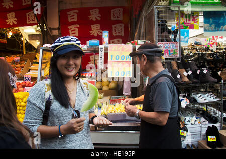 Traveler femme thaïlandaise l'achat de fruits melon vendeur greengrocery japonais et voyager à Ameyoko market à Ueno le 20 octobre 2016 à Tokyo, Japon Banque D'Images