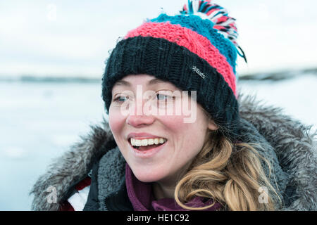 Jeune femme portant chapeau laineux, rire, portrait, Fjallsárlón Lagoon, Iceland Glacier Banque D'Images