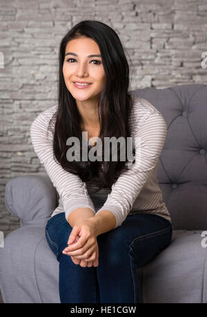 Femme assise sur un fauteuil Banque D'Images