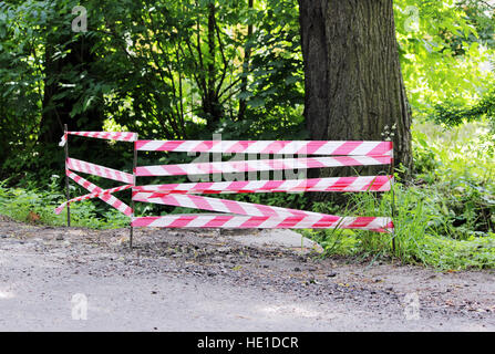 Rouge Blanc ruban d'avertissement l'escrime est protège la trappe ouverte. Banque D'Images