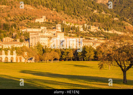 Ruines du théâtre romain de Gubbio avec le centre-ville médiéval derrière sur le Mont Ingino, province de Pérouse, Ombrie, Italie. Banque D'Images
