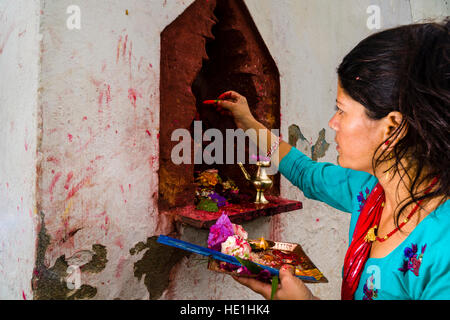 Une femme s'offrant à l'prasad statues des dieux en dehors du temple khadga devi mandir au festival hindouiste darsain Banque D'Images