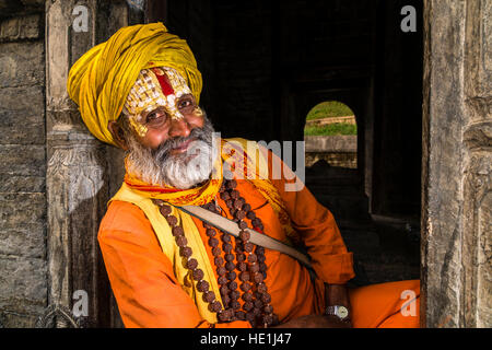 Le portrait d'un sadhu, saint homme, assis à un petit sanctuaire au temple de Pashupatinath sur les rives de la rivière Bagmati Banque D'Images