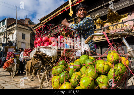 Les vendeurs de fruits, à l'aide de vélos, offrent des pommes et des oranges sur indra chowk en face de temple akash bhairab Banque D'Images