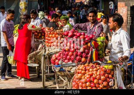 Les vendeurs de fruits, à l'aide de vélos, offrent des pommes et des oranges sur indra chowk en face de temple akash bhairab Banque D'Images