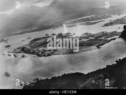 Photographie prise à partir d'un avion japonais au cours de l'attaque de torpilles sur les navires amarrés sur les deux côtés de l'île de Ford. La vue s'étend sur l'est, avec dépôt d'approvisionnement, base sous-marine et le réservoir de combustible ferme dans la bonne distance du centre. Une torpille vient de frapper le USS West Virginia de l'autre côté de l'Île Ford center. D'autres navires amarrés à proximité sont de gauche : Nevada, Arizona, Utah à l'intérieur de la Virginie de l'Ouest, Oklahoma torpillé et l'inscription aux côtés du Maryland, et de la Californie. Sur le côté près de l'île de Ford, à gauche, sont des croiseurs légers Detroit et Raleigh, cible et navire de formation et de l'Utah dix hydravions Banque D'Images