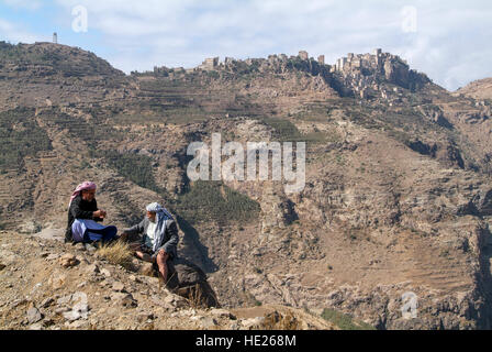 Al Hajjarah, Yémen - 8 janvier 2016 : Deux homme assis devant le village d'Al Hajjarah sur montagnes Haraz, Yémen Banque D'Images