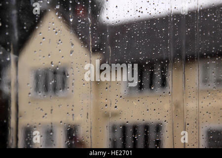 Une chambre vue à travers la pluie sur une fenêtre. Banque D'Images