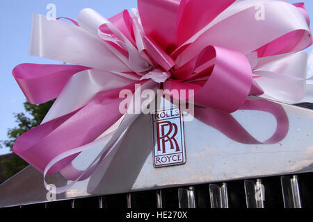 Rolls Royce logo sur une voiture de mariage, attachés avec un ruban rose et blanc bow Banque D'Images