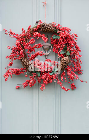 Couronne de Noël décoratif suspendu par une porte avant gris. Banque D'Images