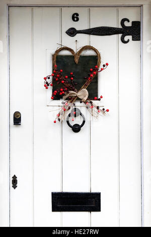 Guirlande de noël décorative blanche accrochée à un porte avant. Banque D'Images