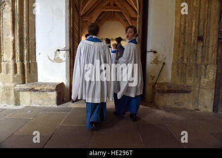 Les choristes de Wells Cathedral Choir en soutanes et surplices marcher le long des cloîtres après la messe le jour de Pâques. Banque D'Images