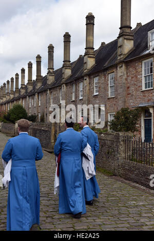 Les vicaires, Wells Cathedral Choir Chorale, marcher dans leurs foyers en vicaires fermer après la messe à la cathédrale le jour de Pâques. Banque D'Images