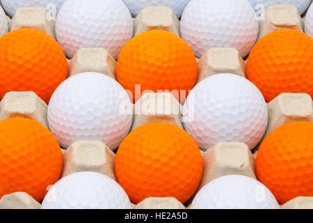 Balles de golf blanc et orange dans la boîte pour les oeufs Banque D'Images