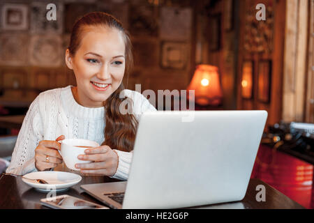 Yong femme un travail à laptop in cafe Banque D'Images