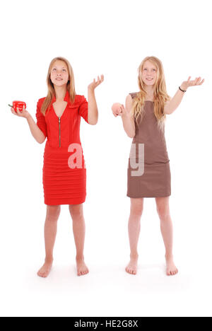 Deux jeunes filles faire semblant que jongler avec des fruits, isolated on white Banque D'Images