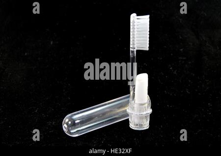 Brosse à dents en plastique transparent pour voyager sur un fond noir Banque D'Images