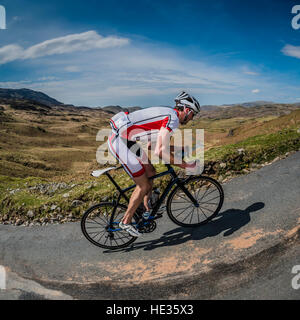 Un homme escalade Hardknott Pass cycliste dans le Lake District, UK. Logo ont été supprimés. Banque D'Images