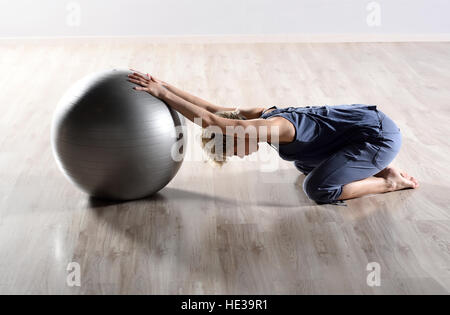 Jeune femme fit faire des exercices de Pilates avec un grand ballon de gymnastique Banque D'Images