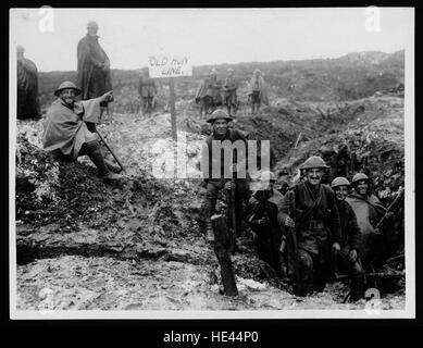 Cette photographie historique de la première Guerre mondiale montre un soldat britannique, Tommy, du 16e bataillon, profitant d'un moment de possession d'une tranchée allemande capturée. L'image reflète les conditions de la ligne de front pendant le conflit de 1914-1918. Banque D'Images