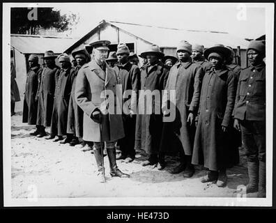 Cette image historique montre le général Jan Smuts inspectant une unité de travail indigène sud-africaine, qui faisait partie des efforts au début du XXe siècle. L'unité se composait de travailleurs autochtones employés en temps de guerre et de diverses activités industrielles. Le général Smuts était une figure éminente de l'histoire sud-africaine et britannique, connu pour son rôle dans les deux guerres mondiales et la création de l'Union sud-africaine. Banque D'Images