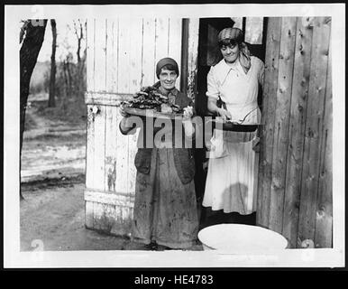Cette image historique représente deux cuisinières du First Aid Nursing Yeomanry, un groupe de femmes bénévoles qui ont servi à divers titres pendant la première Guerre mondiale. La photographie montre leur rôle important dans la fourniture de soutien en temps de guerre, soulignant leur contribution aux efforts médicaux et logistiques. Banque D'Images