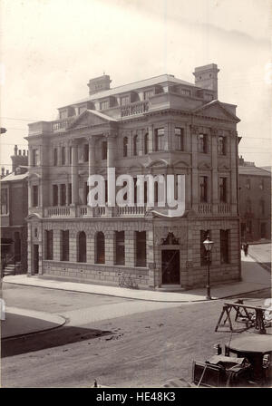 Cette image historique de Hartlepool montre Church Street avec son bâtiment bancaire et une voiture au premier plan. La scène capture l'essence de la vie urbaine britannique du début du XXe siècle à West Hartlepool, offrant un aperçu du paysage architectural et social de l'époque. Banque D'Images