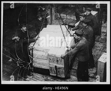 Cette image historique représente le processus de déchargement d'un navire d'approvisionnement alimentaire, une scène commune des siècles passés, illustrant la logistique du commerce maritime et de l'approvisionnement au cours des époques antérieures. Banque D'Images