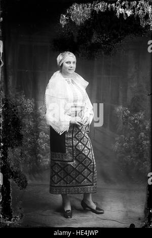 Une femme vêtue d'un costume folklorique roumain traditionnel, capturée dans une photographie historique d'Ialomita, reflétant le patrimoine culturel de la Roumanie. Banque D'Images