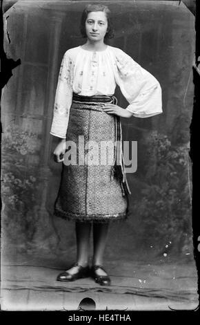 Une jeune femme vêtue d'un costume traditionnel roumain, capturée par Costica Acsinte dans une photographie de plaque de verre vintage. Banque D'Images