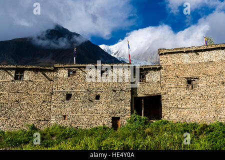 Certaines maisons de la partie ancienne de manang sont mis en place comme un mur de protection, la montagne Annapurna 3 dans la distance Banque D'Images