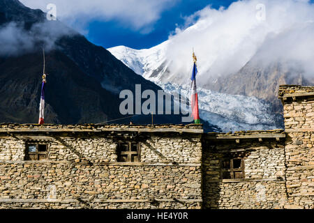 Certaines maisons de la partie ancienne de manang sont mis en place comme un mur de protection, la montagne et le glacier gangapurna dans la distance Banque D'Images