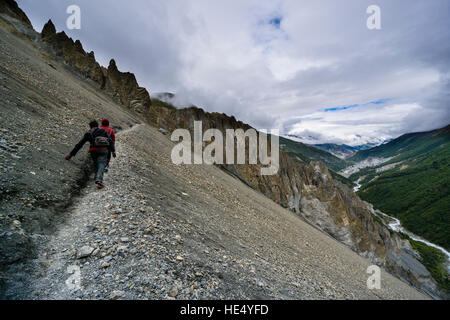La route vers le lac Tilicho trekking est le croisement dangereux les pentes des montagnes de la haute vallée de la Marsyangdi, 2 hommes marchent sur elle Banque D'Images