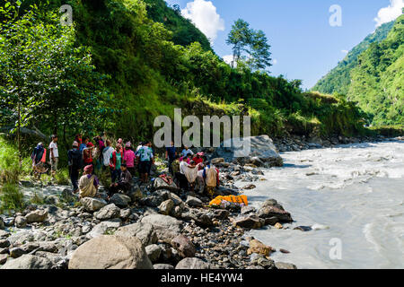 Un groupe d'agriculteurs locaux sont prepairing l'enterrement d'un corps mort à la crémation la masse sur la rive de la rivière Kali Gandaki Banque D'Images