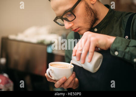 Image main d'hommes libre de l'ajout de crème au café. Banque D'Images