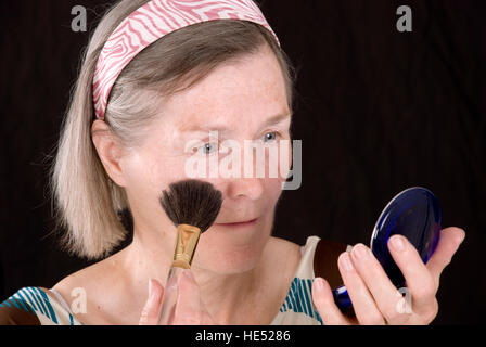 Femme, de plus de 65 ans, en mettant sur le maquillage Banque D'Images