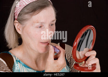 Femme, de plus de 65 ans, en mettant sur le maquillage Banque D'Images