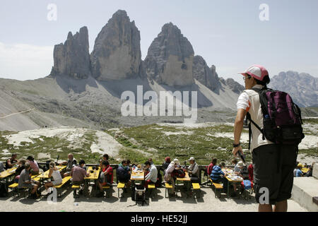 Les touristes en faisant une pause sur la terrasse de l'Dreizinnenhuette cabane de montagne, en face de l'Tre Cime di Lavaredo ou montagnes Banque D'Images