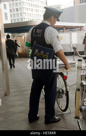 Des policiers japonais d'arrêter les gens de vélo vélo après vérification des vélos sur tout le trafic sur route à la gare JR Tokyo, le 20 octobre 2016 à Tokyo, Banque D'Images