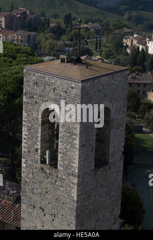 Cross surmonté d'une tour sur la Via St Matteo, et une partie de la Duomo complexe. La ville médiévale de San Gimignano, Toscane, Italie. Banque D'Images