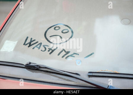 Voiture sale avec 'Lavez-moi' écrit sur l'écran du vent Banque D'Images