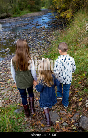 Trois enfants qui sont frères et sœurs dans un style franc à l'extérieur photo le long des rives de la rivière McKenzie dans l'Oregon. Banque D'Images